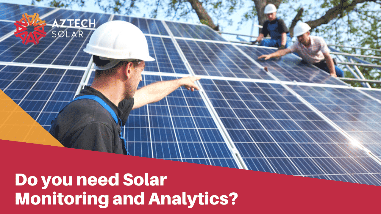 Solar installers inspecting rooftop panels during a monitoring system check