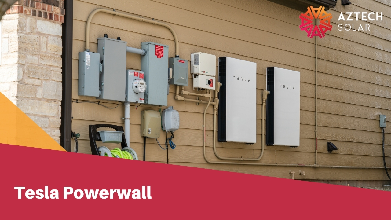Tesla Powerwall battery mounted on a residential garage wall with connected solar inverter