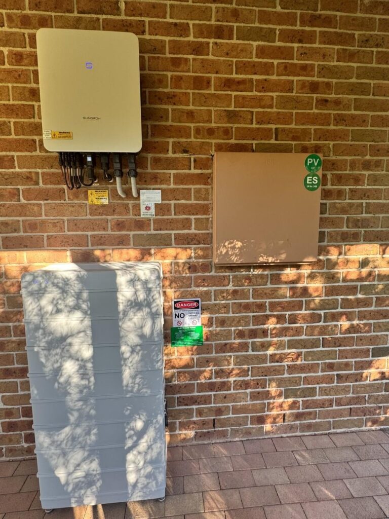 Solar inverter and electrical panel on brick wall.