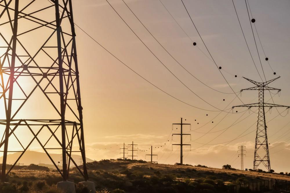 Power lines and towers at sunset.